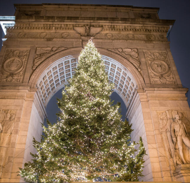 The Washington Square Park Christmas tree lit up underneath the historic Greenwich Village arch.